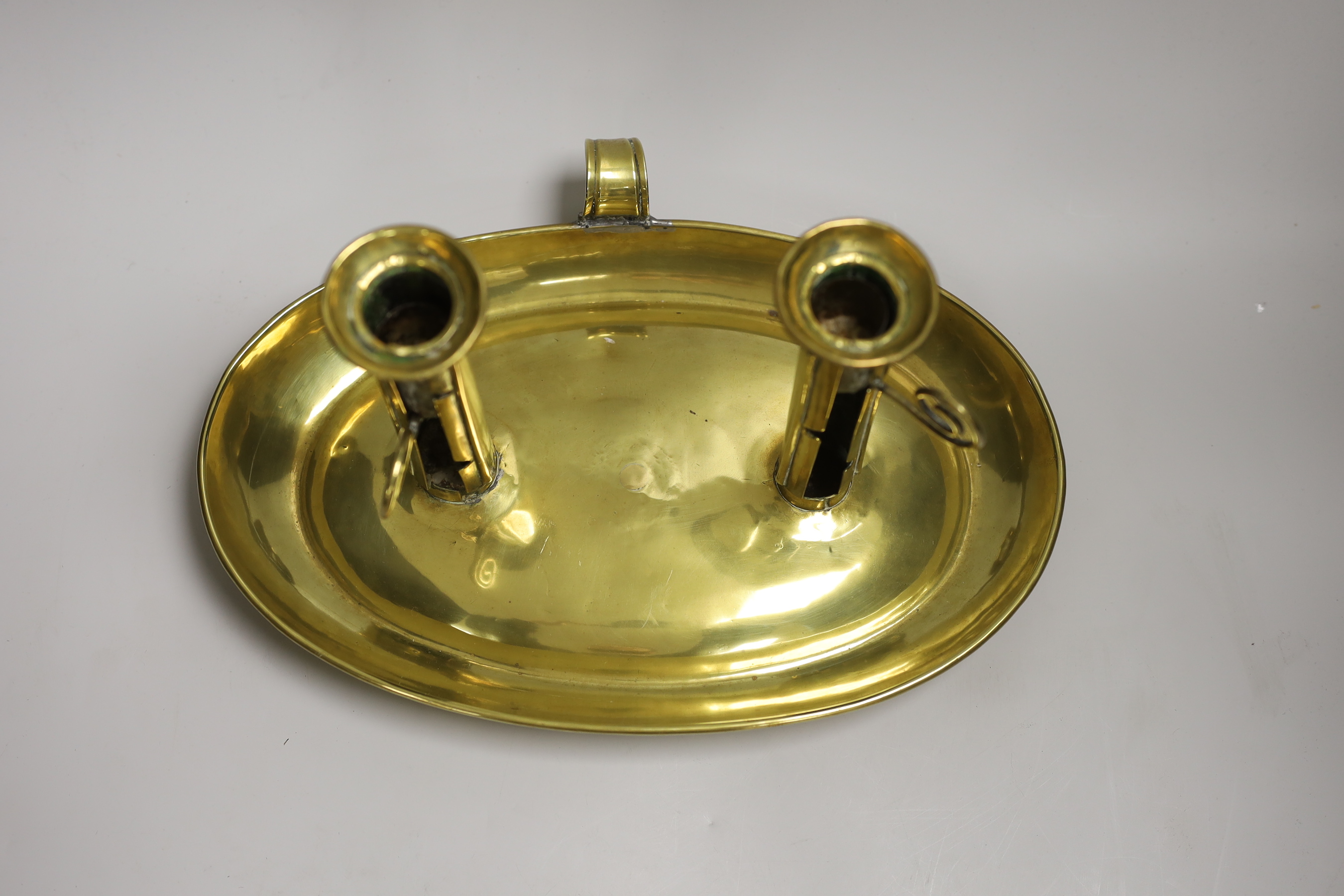 A large brass double chamber candlestick, English c.1800, with oval trap, 33cm wide